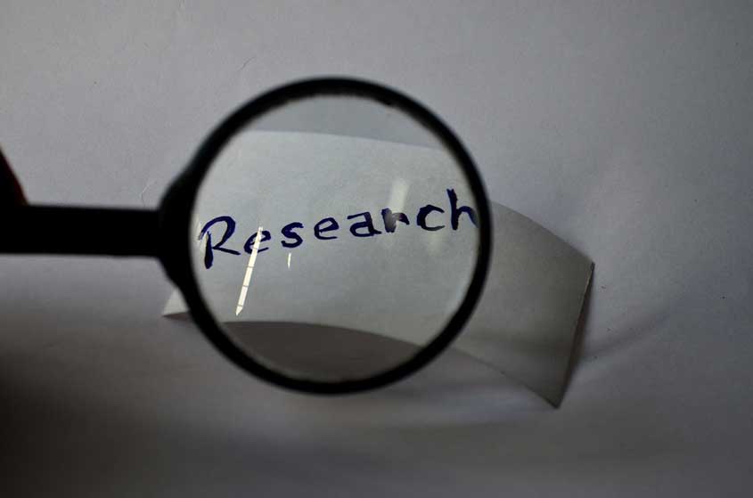 Written word 'research' seen through magnifying glass