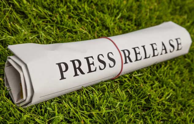 rolled-up newspaper with the words 'press release'